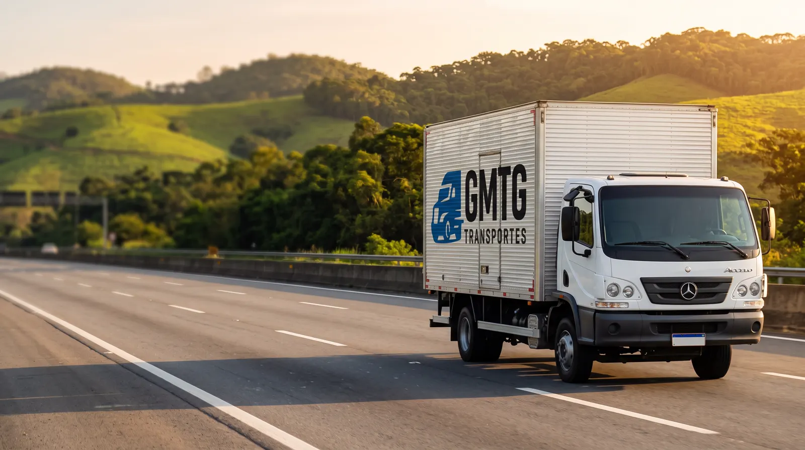 Caminhão baú da GMTG Transportes com a logo da empresa, rodando em uma rodovia de São Paulo
